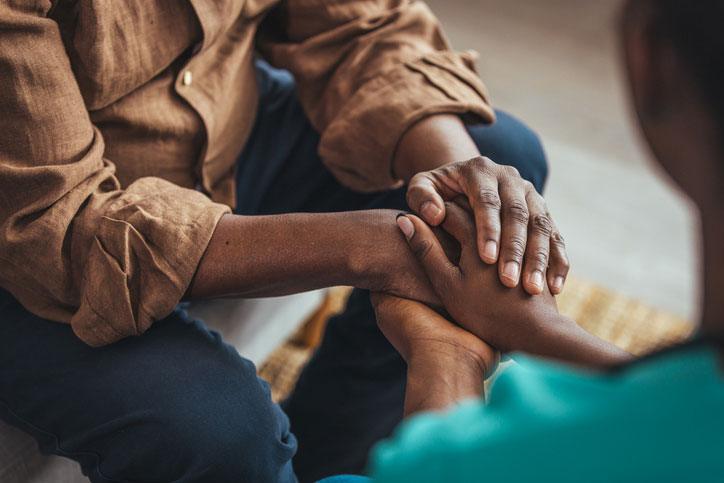 social worker holding the hands of the grieving