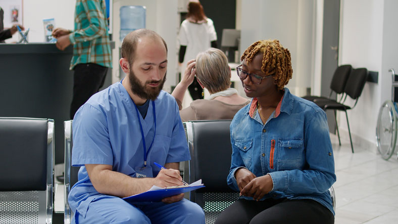 healthcare social worker talking with woman in waiting room