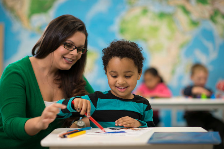 social worker helping young boy in classroom