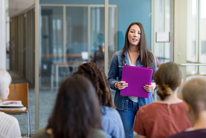 young woman giving presentation to class