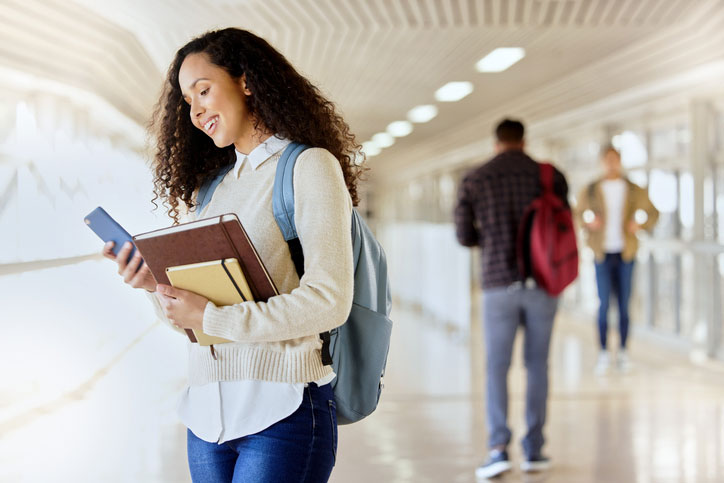 young woman looking at her phone between classes