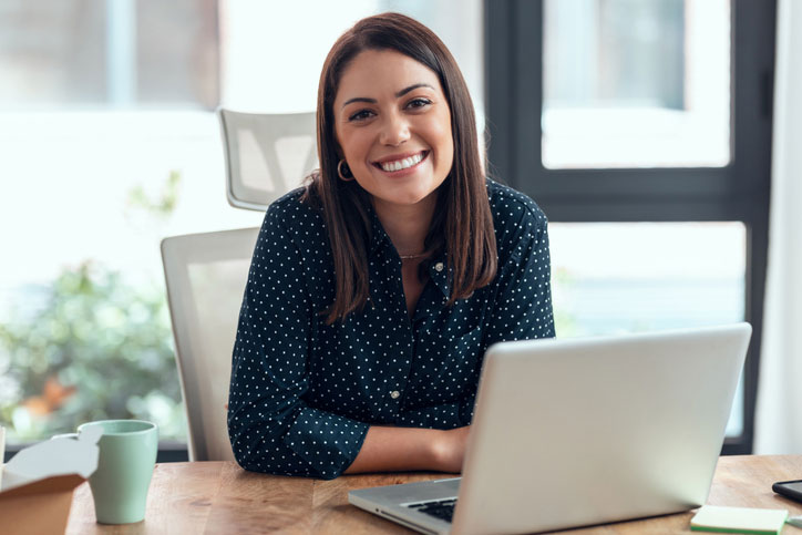 phd student looking up from her laptop smiling