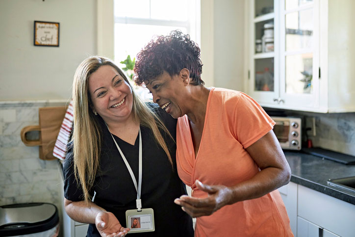 older woman laughing with her social worker