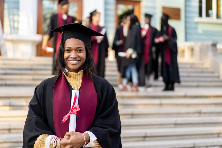 smiling female graduate in cap and gown