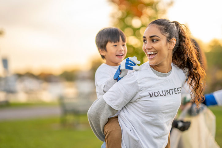 volunteer giving a young boy a piggyback ride