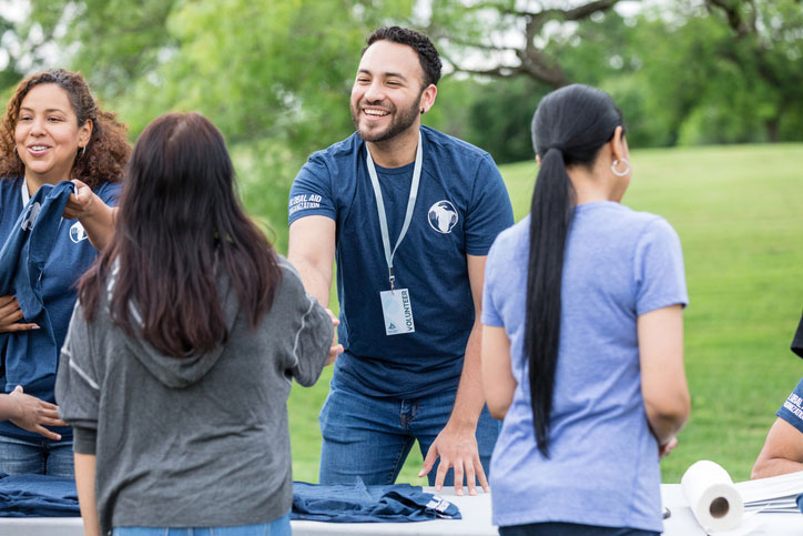 young man shaking hands with volunteers