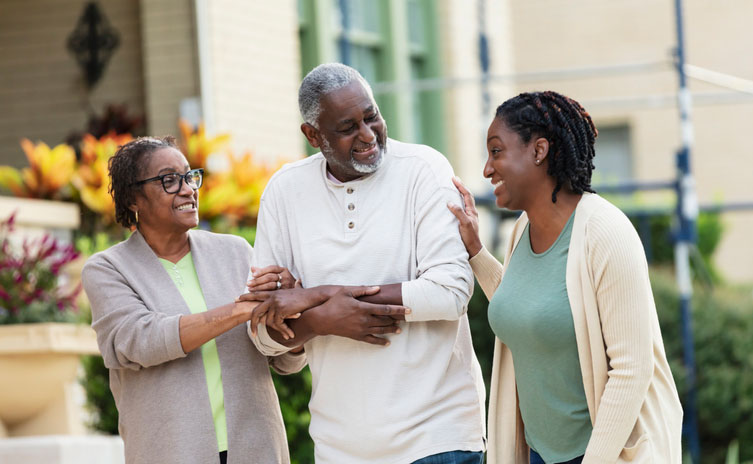 elderly, black couple walking with their social worker