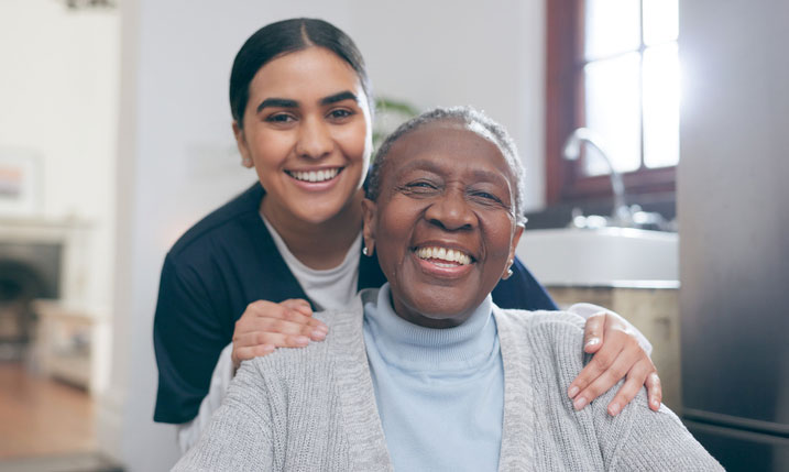 social worker and elderly woman in wheelchair smiling