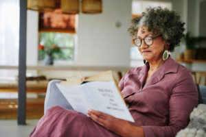 elderly woman reading on sofa