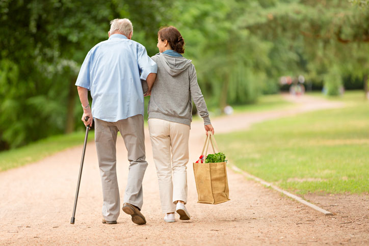 carrying groceries and helping elderly man walk