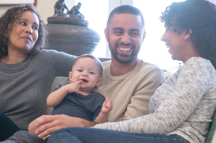 family holding infant on sofa