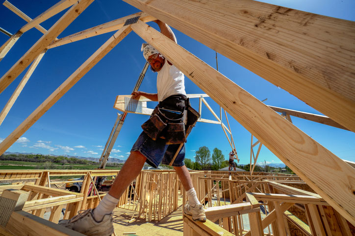 construction worker up high in new house rafters