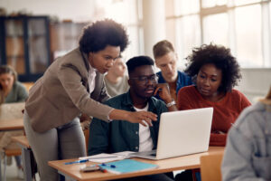 group watching on as professor shows them something on the computer