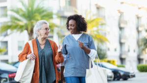 young woman helping elderly woman with her bags