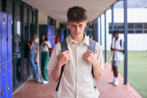 boy walking alone in outdoor corridor 