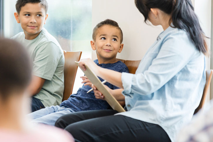 mom with two sons filling out paperwork