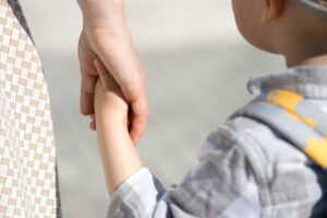 young boy holding mom's hand