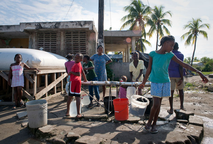 children filling water buckets