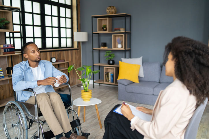 wheelchair-bound man talking with counselor